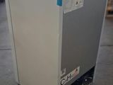a white refrigerator sitting on the floor in a warehouse