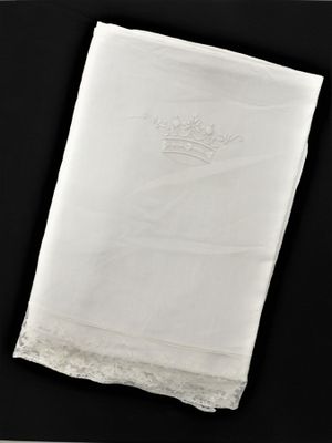 mouchoir blanc sur lequel est brodée une couronne sur fond noir
