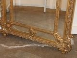 a large gold mirror sitting on the floor in a room