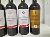 three bottles of red wine are lined up on a table