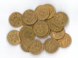 une pile de pièces d'or posée sur une surface blanche