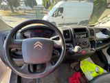 a steering wheel and dashboard of a car with a van in the background