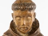 statue of a man in a monk ' s robes with a cap on his head