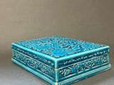 two small blue boxes sitting on top of a table next to each other
