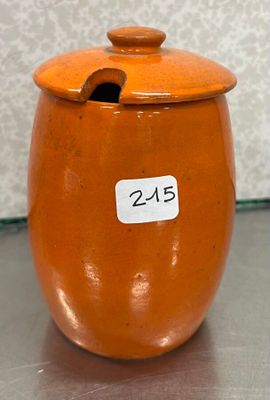 un bocal orange muni d'une étiquette, posé sur une table