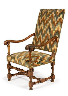 un fauteuil rembourré dont le dossier et les accoudoirs sont recouverts d'un tissu à motifs
