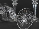 three wine glasses and a bottle on a table