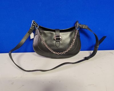 a black purse with a chain around the strap on a white table