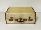 an old suitcase sitting on a white surface