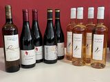 plusieurs bouteilles de vin posées sur une table à côté d'une caisse de vin