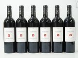 six bouteilles de vin sont alignées sur une surface blanche