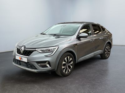 Une voiture grise est garée dans une pièce aux murs blancs.