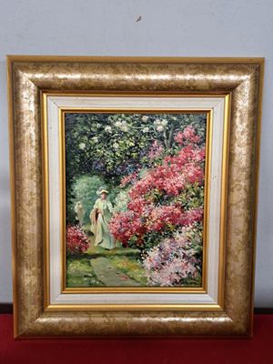 tableau représentant une femme dans un jardin fleuri, dans un cadre doré