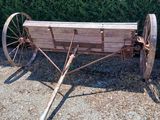 une vieille charrette en bois garée devant une haie