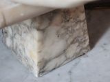 a person cutting a piece of marble with a knife