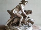 une statue représentant un garçon à cheval accompagné d'un chien