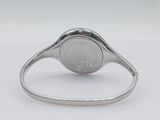 a close up of a silver watch on a white surface