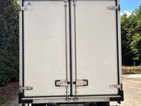 the back of a white truck parked on a gravel road