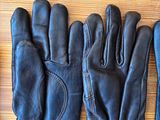 a pair of black leather gloves and a hat on a table