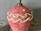 a red vase with a white design on it