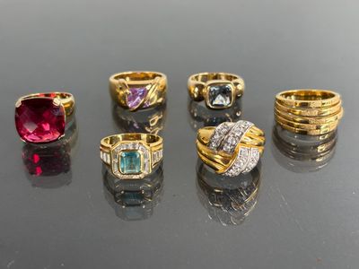 six different colored rings on a black surface with reflection