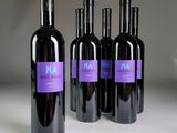three bottles of red wine are lined up on a table