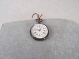 a silver pocket watch with roman numerals on it