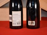 two bottles of wine sitting on a table next to each other