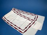 a white towel with red trim on it on a blue surface