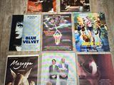 diverses affiches de cinéma posées sur un parquet dans une pièce