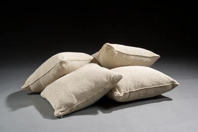 three pillows are stacked on top of each other on a gray surface