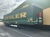 un grand camion vert garé devant un immeuble