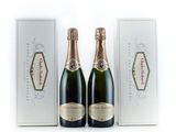 deux bouteilles de champagne devant une boîte blanche