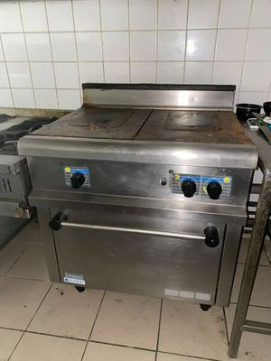 une cuisinière qui se trouve dans une cuisine, à côté d'un plan de travail