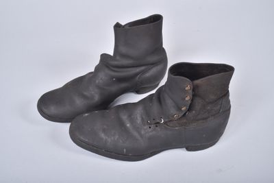 une paire de bottes en cuir noir ornées de boucles sur un fond blanc