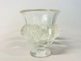 un vase en verre contenant une fleur, posé sur une surface blanche