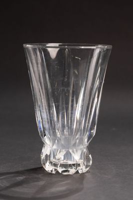 un vase en verre transparent posé sur une table, sur fond noir