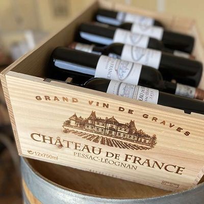 several bottles of wine in a wooden box on top of a table
