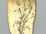 a gold spoon with a flower design on it