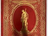 la couverture d'un livre rouge et or sur laquelle figure l'image d'une statue