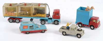 trois petites voitures et un camion posés sur une surface blanche