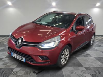la voiture rouge est garée sur un sol en damier dans le garage