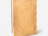 an old book sitting on top of a white surface