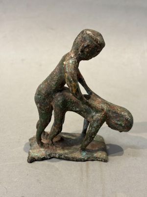 figurine en bronze représentant un garçon tenant un bébé dans ses bras