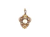un gros plan d'un pendentif en perle et diamants sur fond blanc