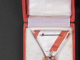 a gold medal in a red case on a black surface