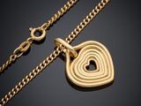 un collier en or avec un pendentif en forme de cœur sur une chaîne