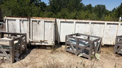 trois caisses en bois posées par terre près d'une clôture