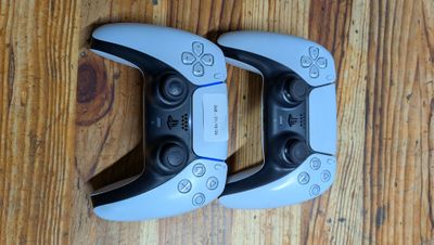 deux manettes de jeux vidéo posées sur un parquet