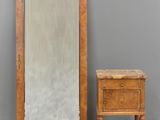 an image of a mirror and a small table in front of a gray wall